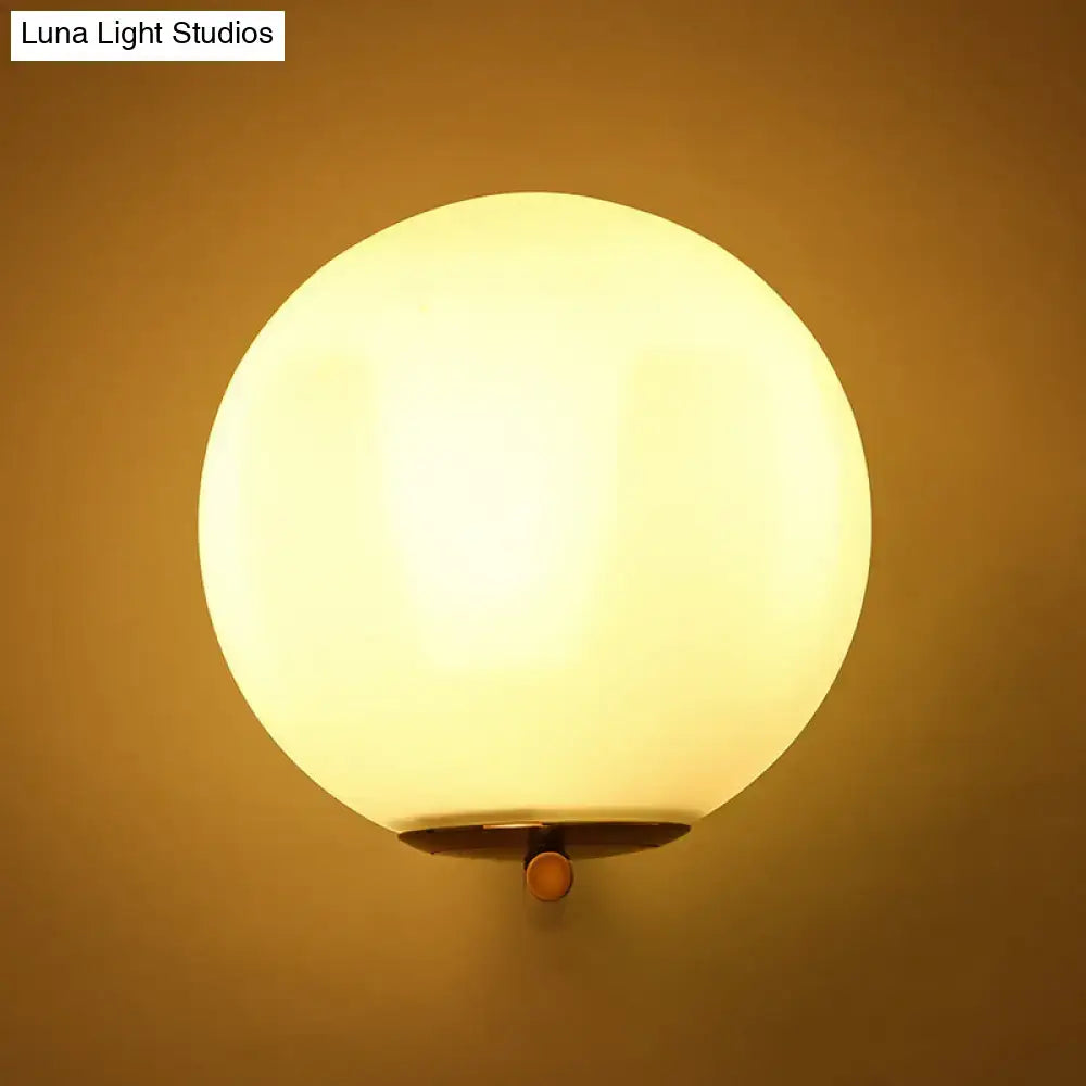 Gold frosted glass ball sconce with brass wall mount; warm glow Decorbites Luna Light Studios on Tampa Home & Garden Store