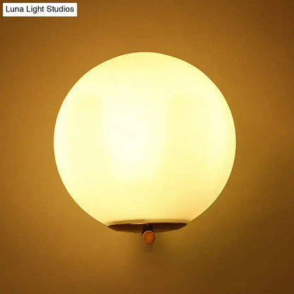 Gold frosted glass ball sconce with brass wall mount; warm glow Decorbites Luna Light Studios on Tampa Home & Garden Store