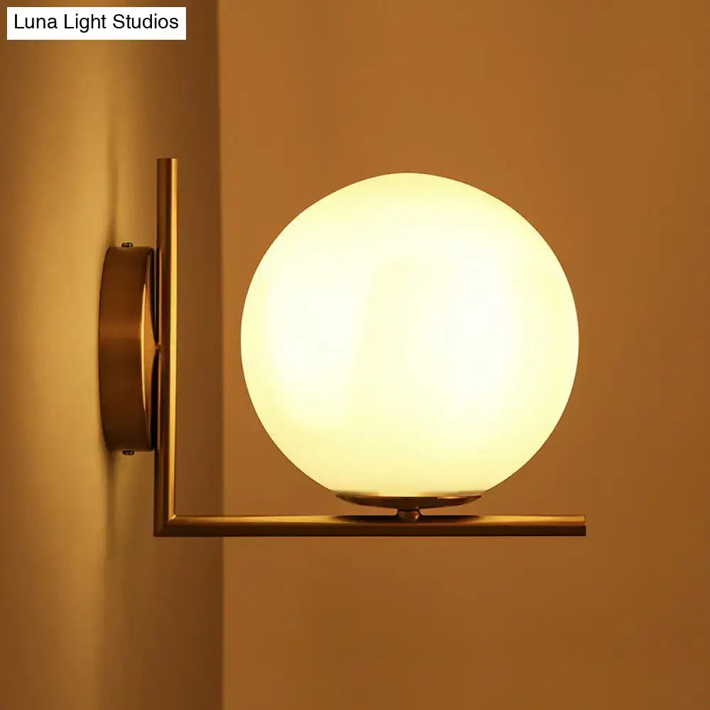 Gold frosted glass ball compact sconce by Decorbites mounted on brass arm on Tampa Home & Garden Store
