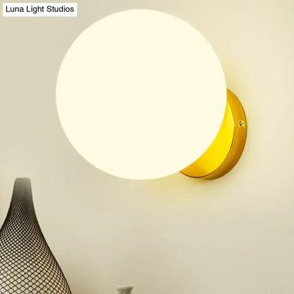 Decorbites gold white glass LED wall sconce with round globe and gold backplate on Tampa Home & Garden Store