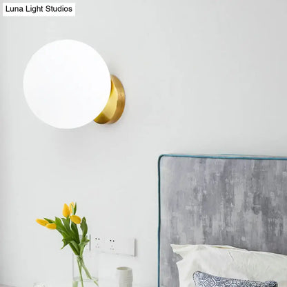 Gold brass wall sconce with frosted white glass globe LED bulb by Decorbites on Tampa Home & Garden Store