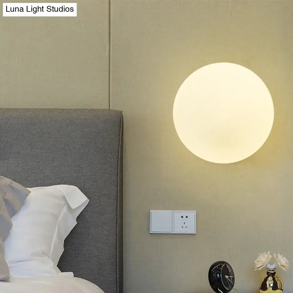Gold White Glass Sconce with LED Bulb, round wall light beside bed in beige bedroom on Tampa Home & Garden Store