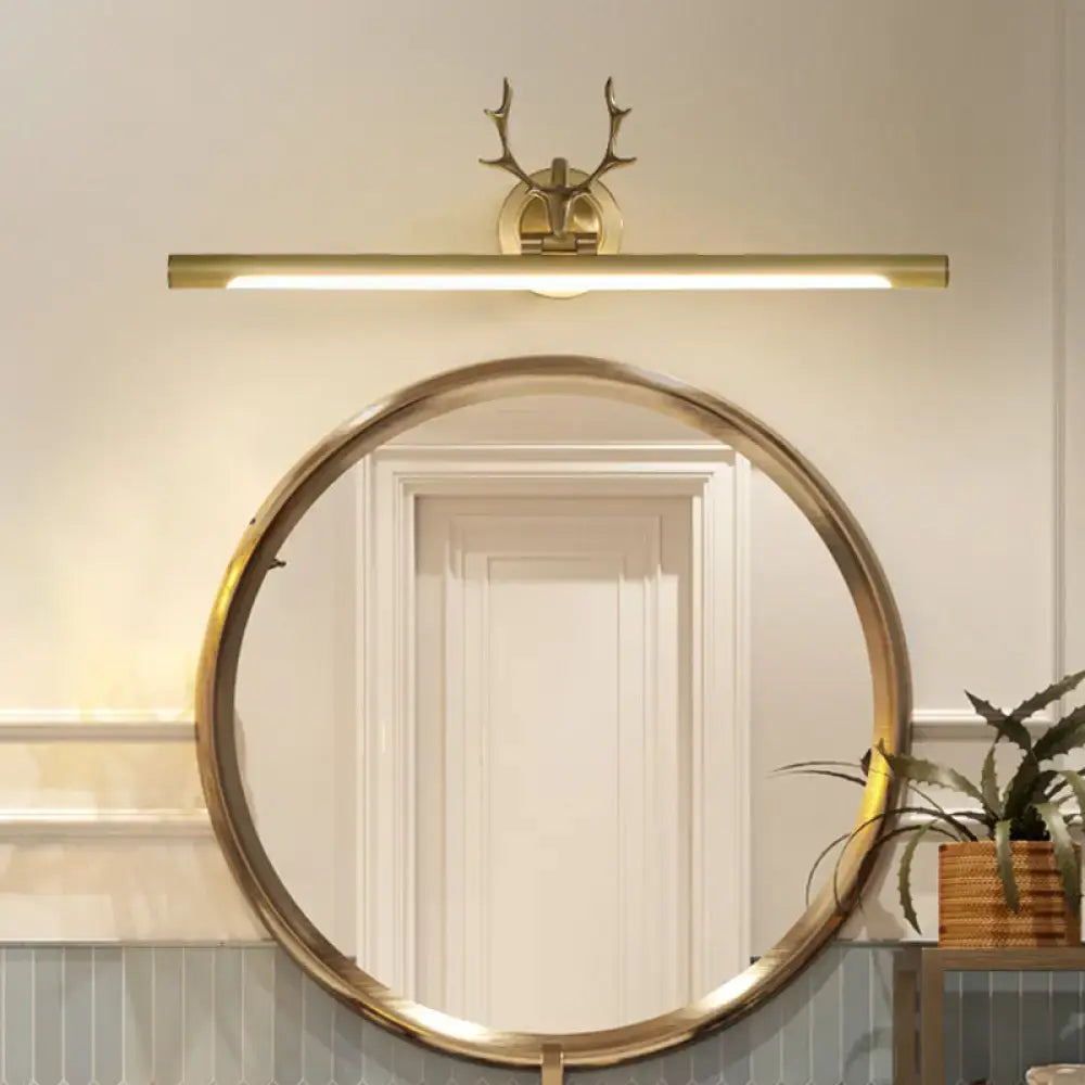 Decorbites gold antler wall sconce with brass finish above a round gold mirror on Tampa Home & Garden Store