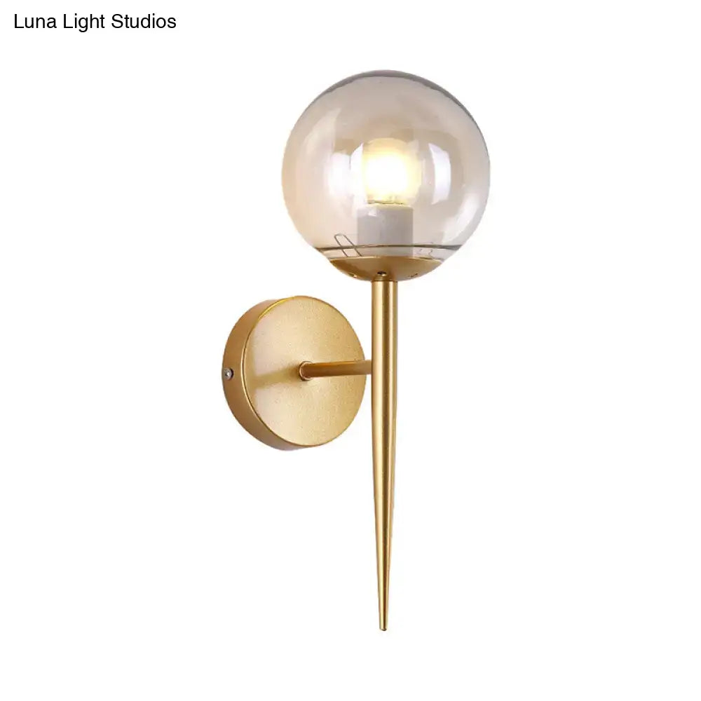 Gold glass globe wall sconce by Decorbites with round backplate and downward tapered spike on Tampa Home & Garden Store