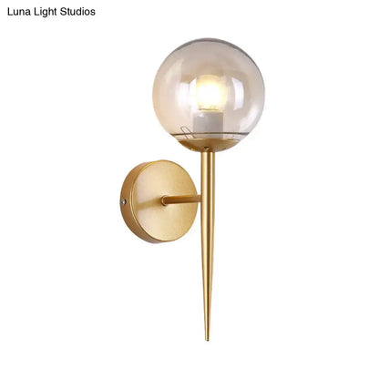 Gold glass globe wall sconce by Decorbites with round backplate and downward tapered spike on Tampa Home & Garden Store