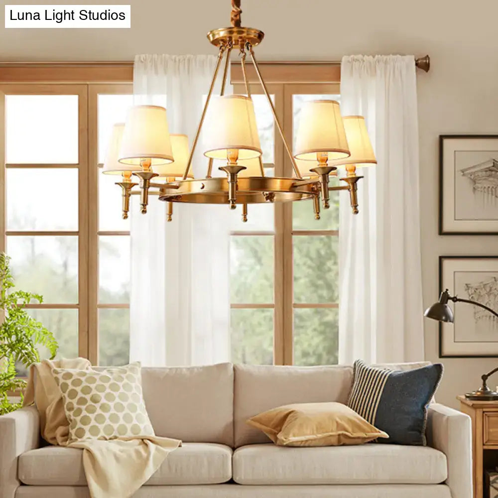 Gold fabric ceiling chandelier Decorbites with brass finish and fabric shades above beige sofa on Tampa Home & Garden Store