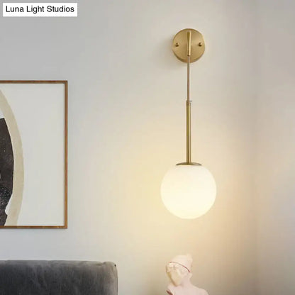 Gold Cream Glass Sconce with brass arm and frosted globe shade wall mounted on Tampa Home & Garden Store