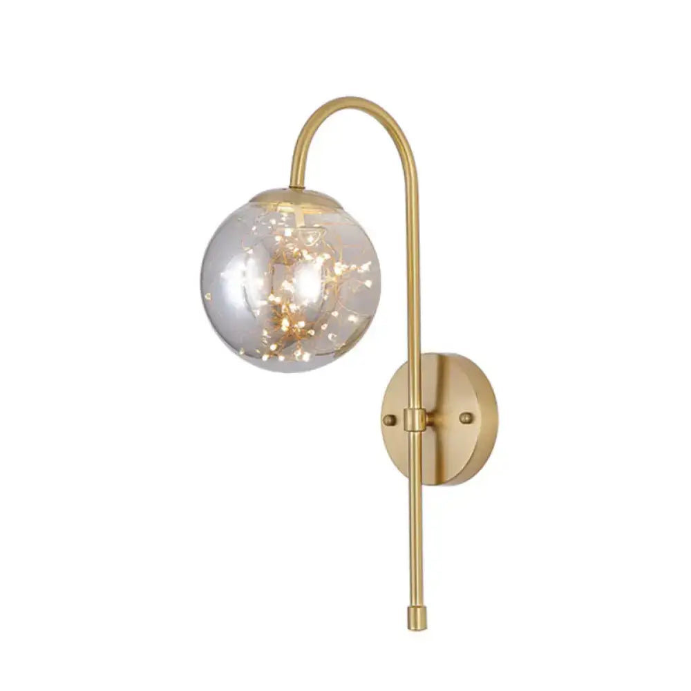 Decorbites gold gooseneck wall light with clear glass globe and string lights on Tampa Home & Garden Store