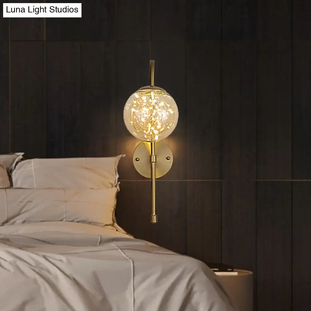 Gold gooseneck wall light by Decorbites with clear glass globe and warm LEDs on dark wood wall on Tampa Home & Garden Store