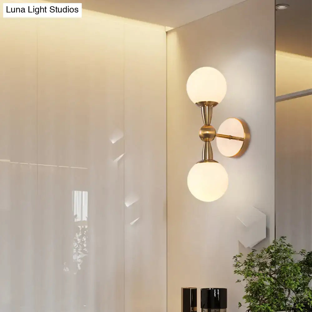 Gold hand blown sconce with brass finish and dual frosted glass globes on Tampa Home & Garden Store