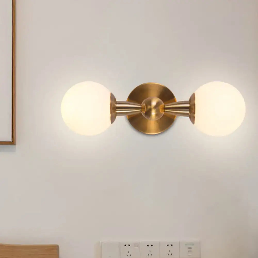 Gold Hand Blown Sconce with dual frosted glass globes on brass mounting and round backplate on Tampa Home & Garden Store