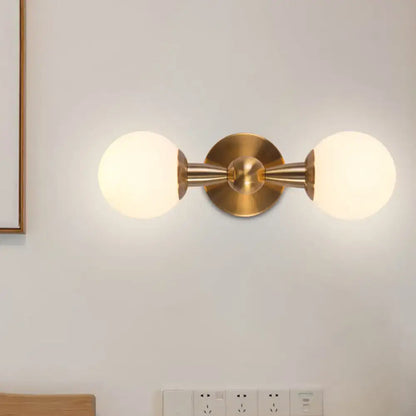 Gold Hand Blown Sconce with dual frosted glass globes on brass mounting and round backplate on Tampa Home & Garden Store
