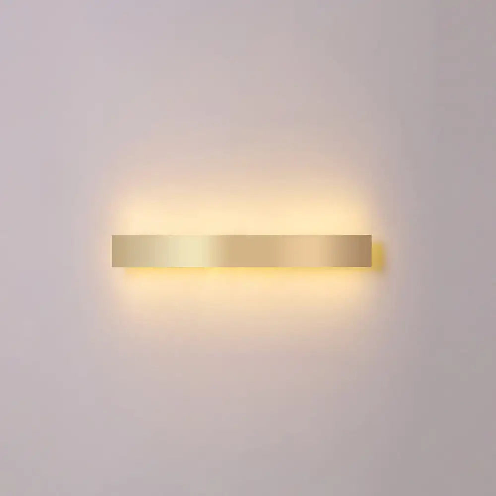 Minimalist gold plated LED wall sconce bar light by Decorbites with warm backlit glow on Tampa Home & Garden Store