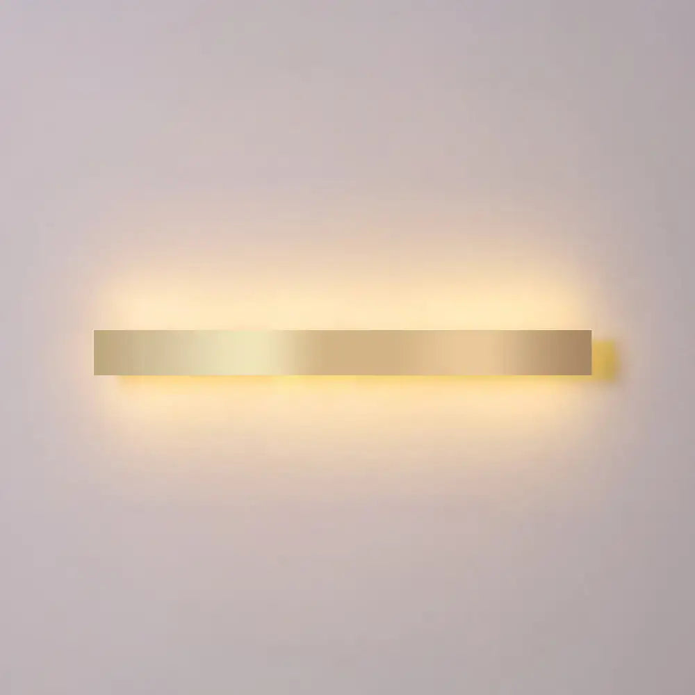 Minimalist gold plated LED wall sconce bar light with a long bar and warm glow on wall on Tampa Home & Garden Store