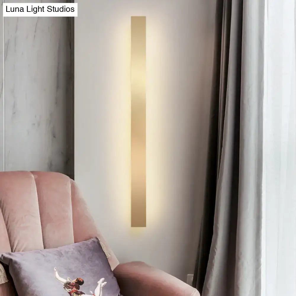 Decorbites minimalist gold LED wall sconce bar light on white wall beside pink velvet sofa on Tampa Home & Garden Store