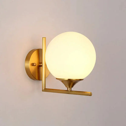 Gold sphere wall sconce with frosted glass globe and brass arm, round backplate on Tampa Home & Garden Store