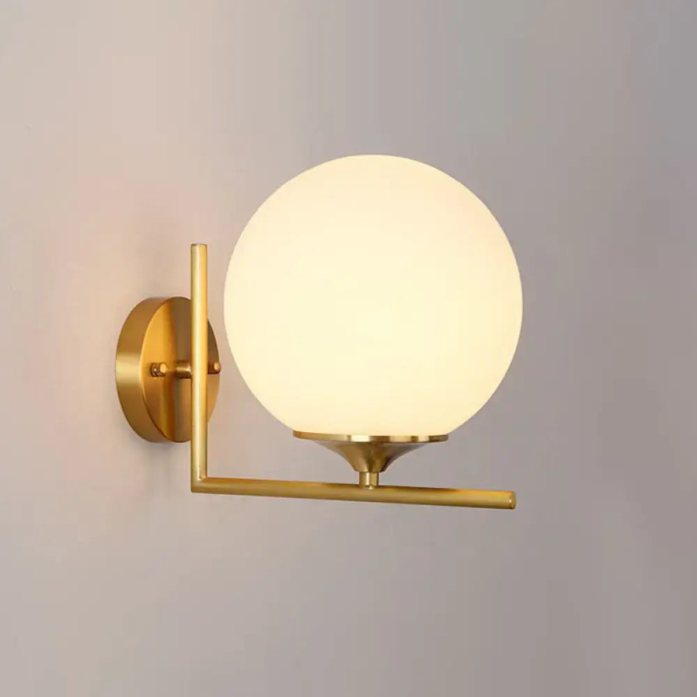 Gold sphere wall sconce by Decorbites with frosted glass globe and brass arm on Tampa Home & Garden Store