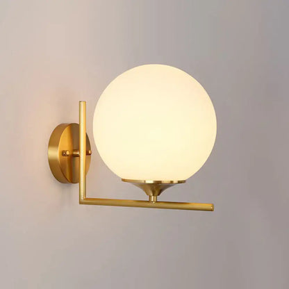 Gold sphere wall sconce by Decorbites with frosted glass globe and brass arm on Tampa Home & Garden Store