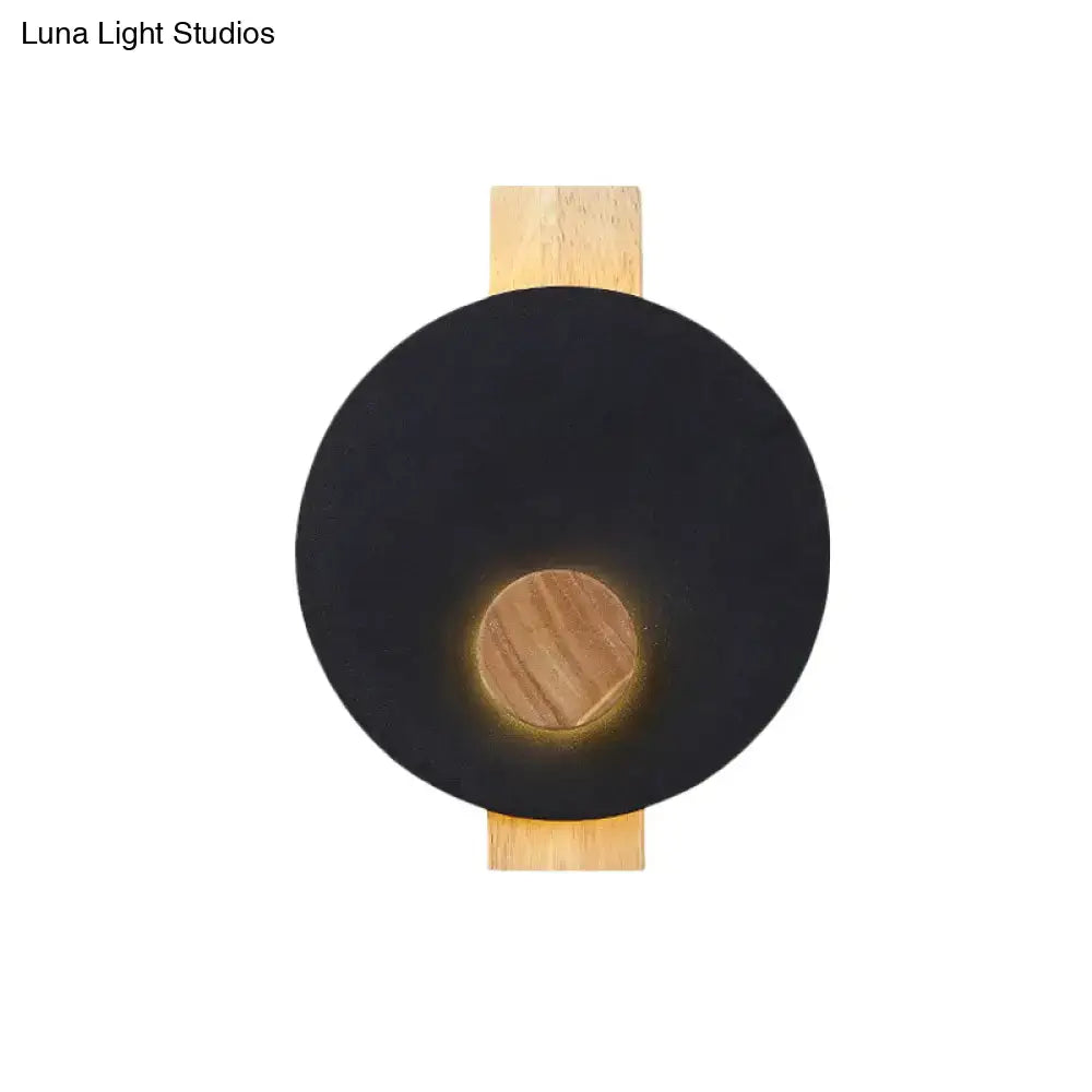 Decorbites gray metal disk sconce with wooden backer, round black face and warm glow on Tampa Home & Garden Store