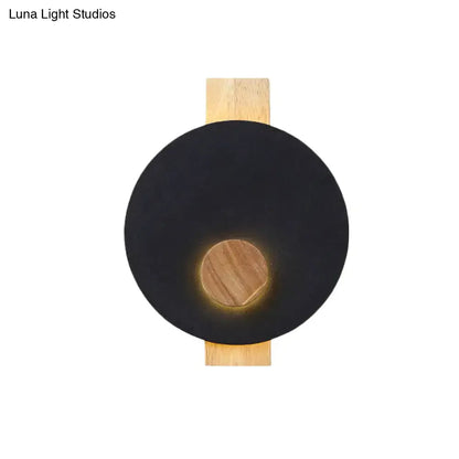 Decorbites gray metal disk sconce with wooden backer, round black face and warm glow on Tampa Home & Garden Store