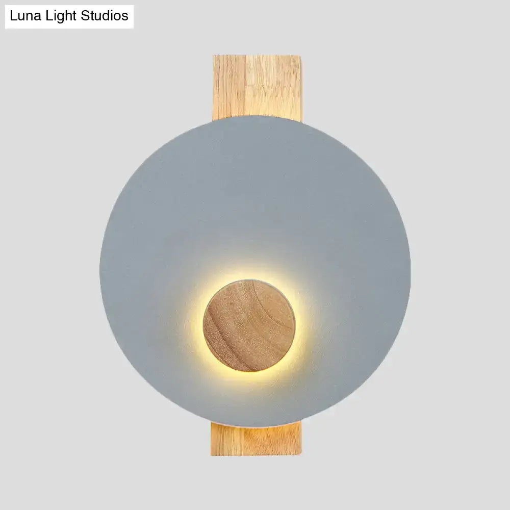 Decorbites gray metal disk wall sconce with wooden backplate and warm glow on Tampa Home & Garden Store