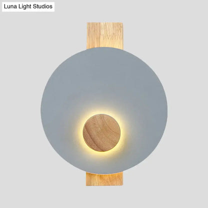 Decorbites gray metal disk wall sconce with wooden backplate and warm glow on Tampa Home & Garden Store