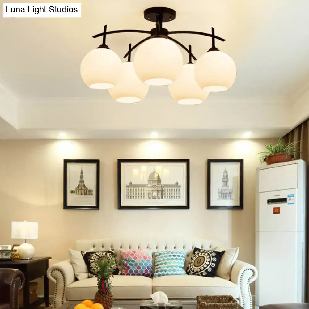 Opal Glass Black Chandelier with five globe lights by Decorbites over a living room sofa on Tampa Home & Garden Store