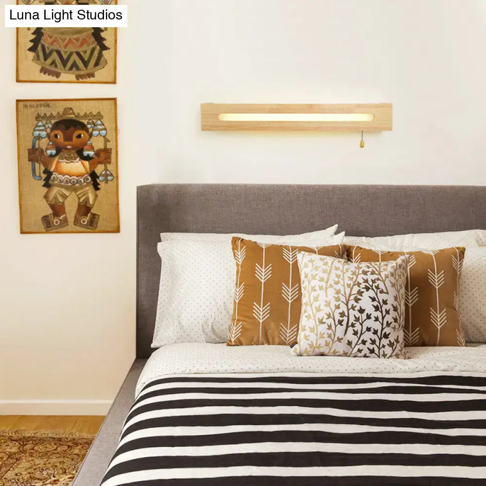 Wood wall sconce light in natural wood finish with a slim long slot and pull chain above bed on Tampa Home & Garden Store