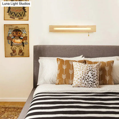 Wood wall sconce light in natural wood finish with a slim long slot and pull chain above bed on Tampa Home & Garden Store