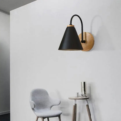 Black conical gooseneck wall sconce with wood backplate on white wall on Tampa Home & Garden Store
