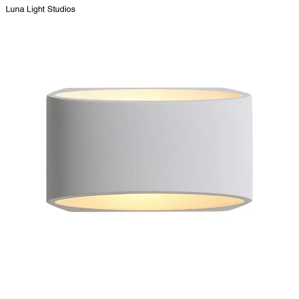 White cylindrical gypsum wall sconce by Decorbites with warm light on Tampa Home & Garden Store