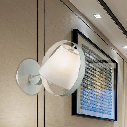 White fabric wall sconce with round metal frame by Decorbites, mounted beside framed art on Tampa Home & Garden Store