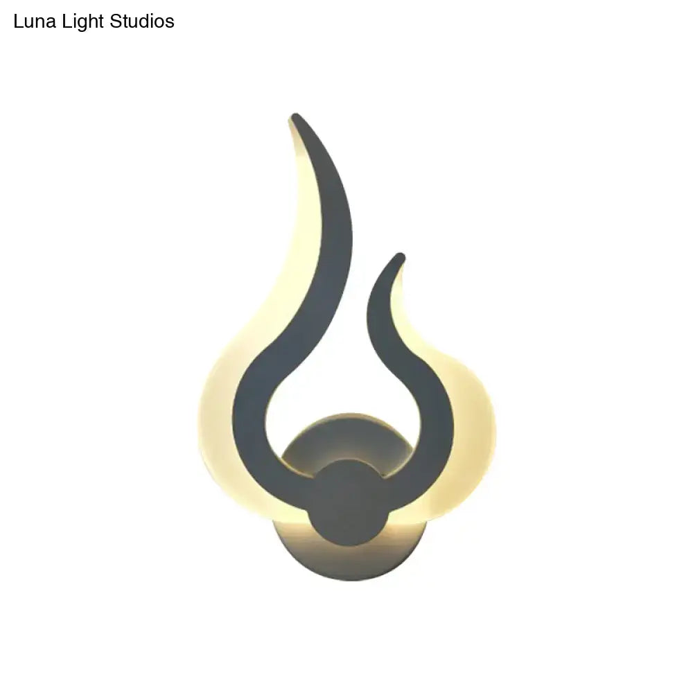 White acrylic flame sconce with dark gray inner flame curves and warm backlit glow on Tampa Home & Garden Store