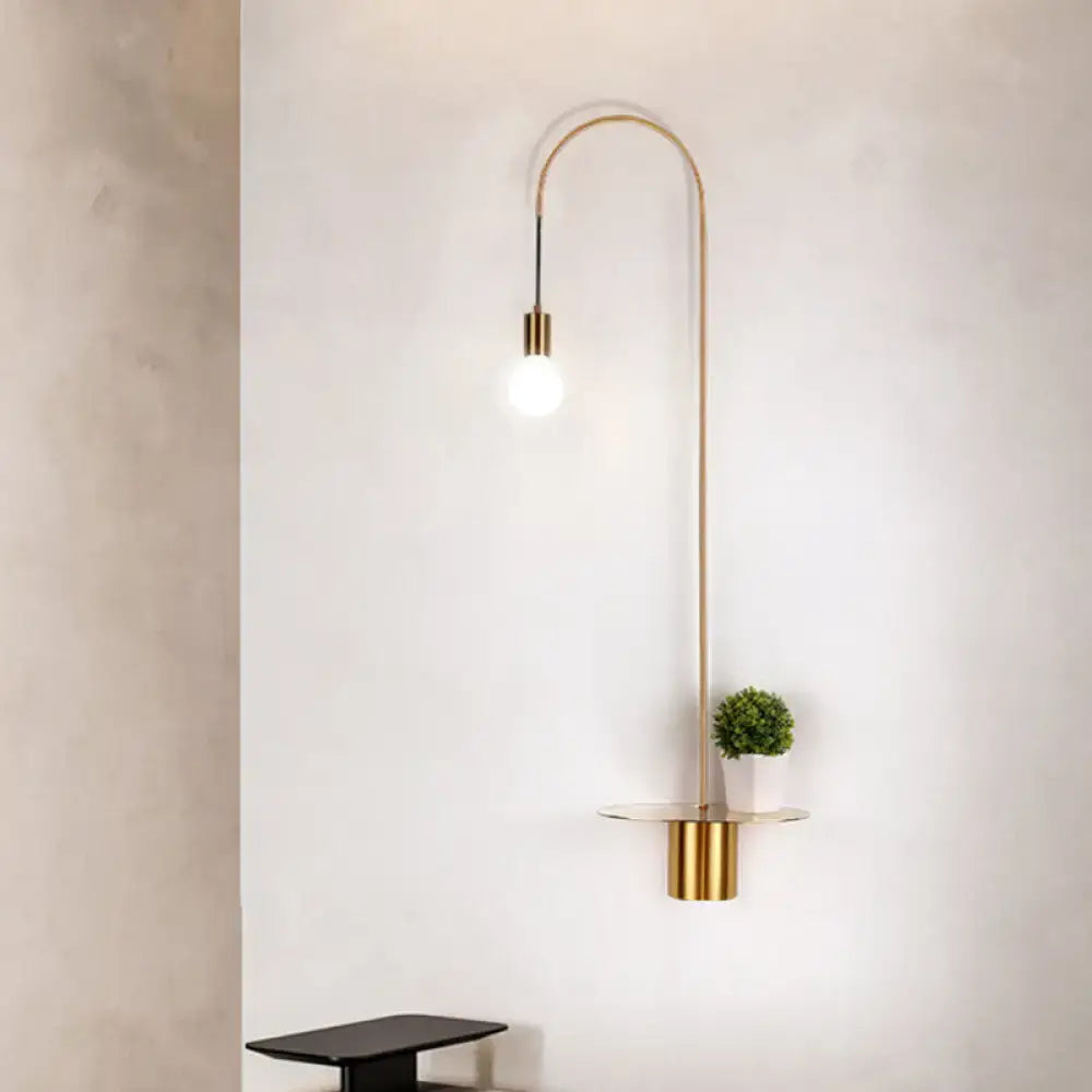 White gooseneck wall sconce by Decorbites with brass accents and exposed bulb, shelf with plant on Tampa Home & Garden Store