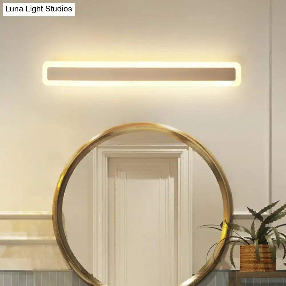Minimalist white LED vanity light wall sconce above a gold round bathroom mirror Decorbites on Tampa Home & Garden Store