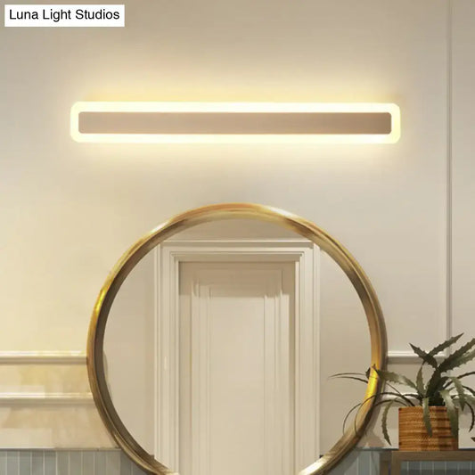 Minimalist white LED vanity light wall sconce above a gold round bathroom mirror Decorbites on Tampa Home & Garden Store