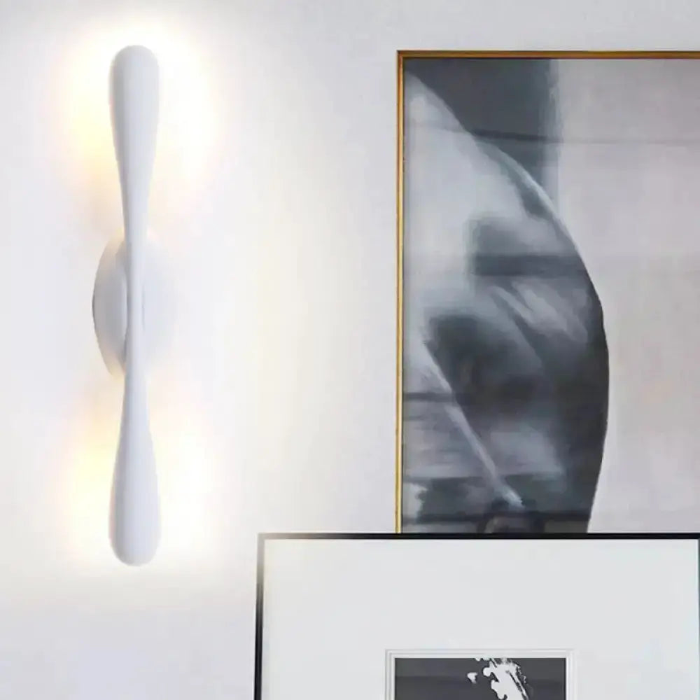 Minimalist white curved wall sconce with vertical form and soft up/down glow on Tampa Home & Garden Store