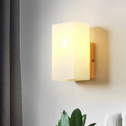 Opal glass wall sconce with warm glow on wood backplate by Decorbites on Tampa Home & Garden Store