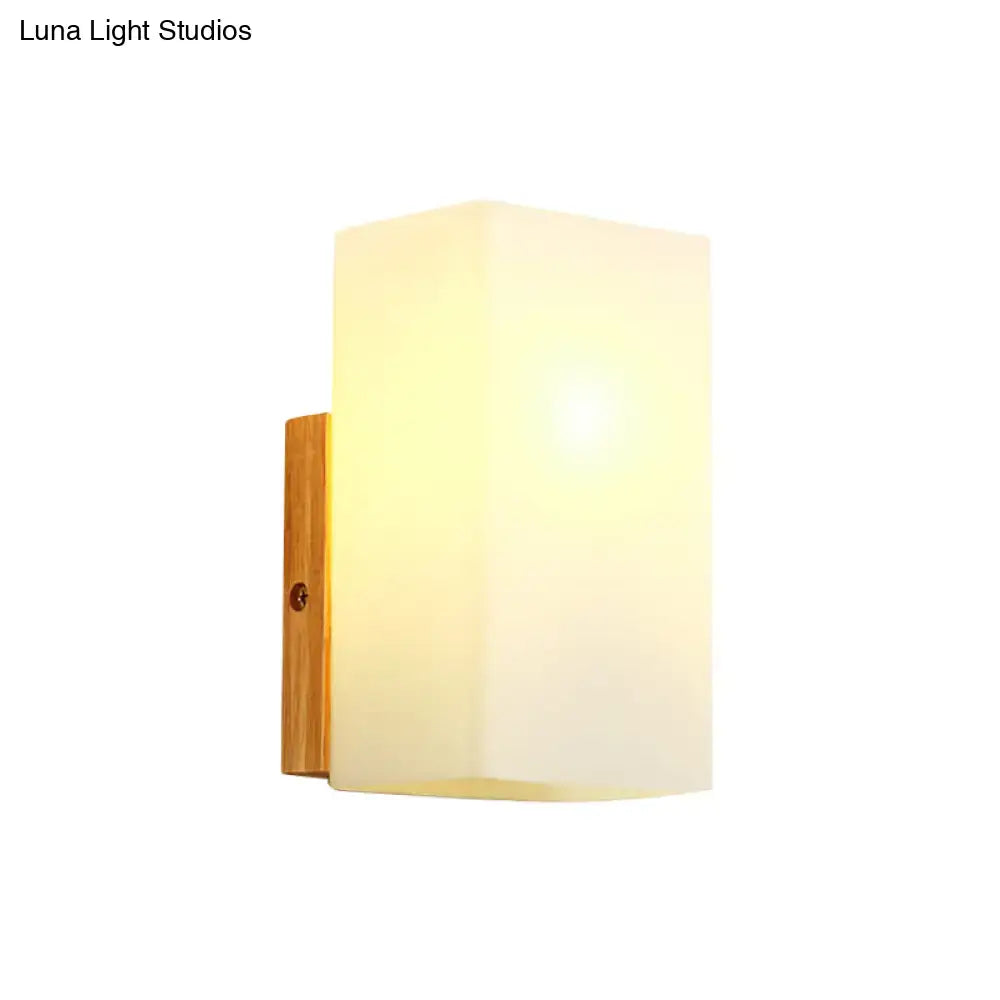 Opal Glass Wall Sconce with warm light and wooden wall mount on Tampa Home & Garden Store