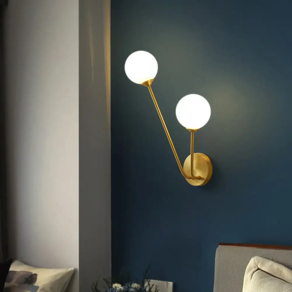 Brass Branch Glass Sconce with dual globe bulbs on dark blue wall on Tampa Home & Garden Store
