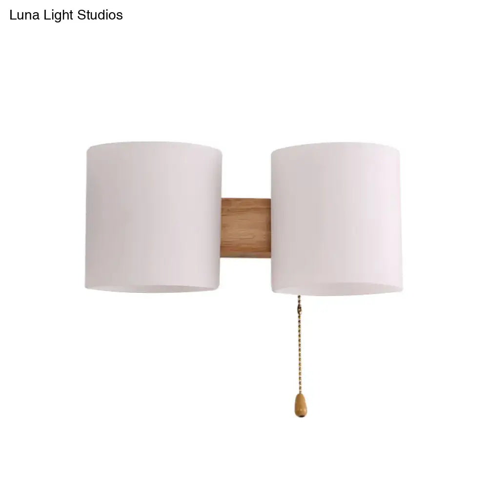 Beige fabric cylinder wall sconce with dual shades on wood backplate by Decorbites pull chain on Tampa Home & Garden Store