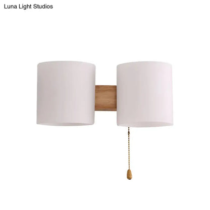 Beige fabric cylinder wall sconce with dual shades on wood backplate by Decorbites pull chain on Tampa Home & Garden Store