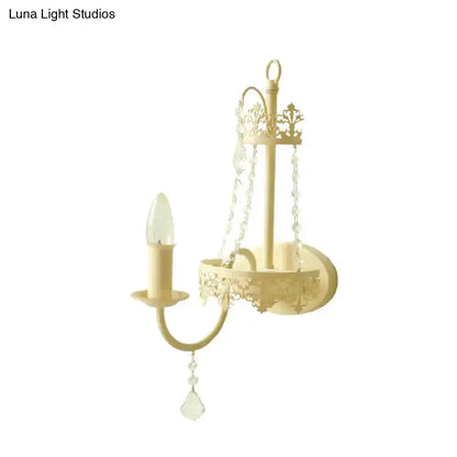 Modern beige ornate crystal sconce with candle bulb and hanging prisms, 15 in Decorbites on Tampa Home & Garden Store