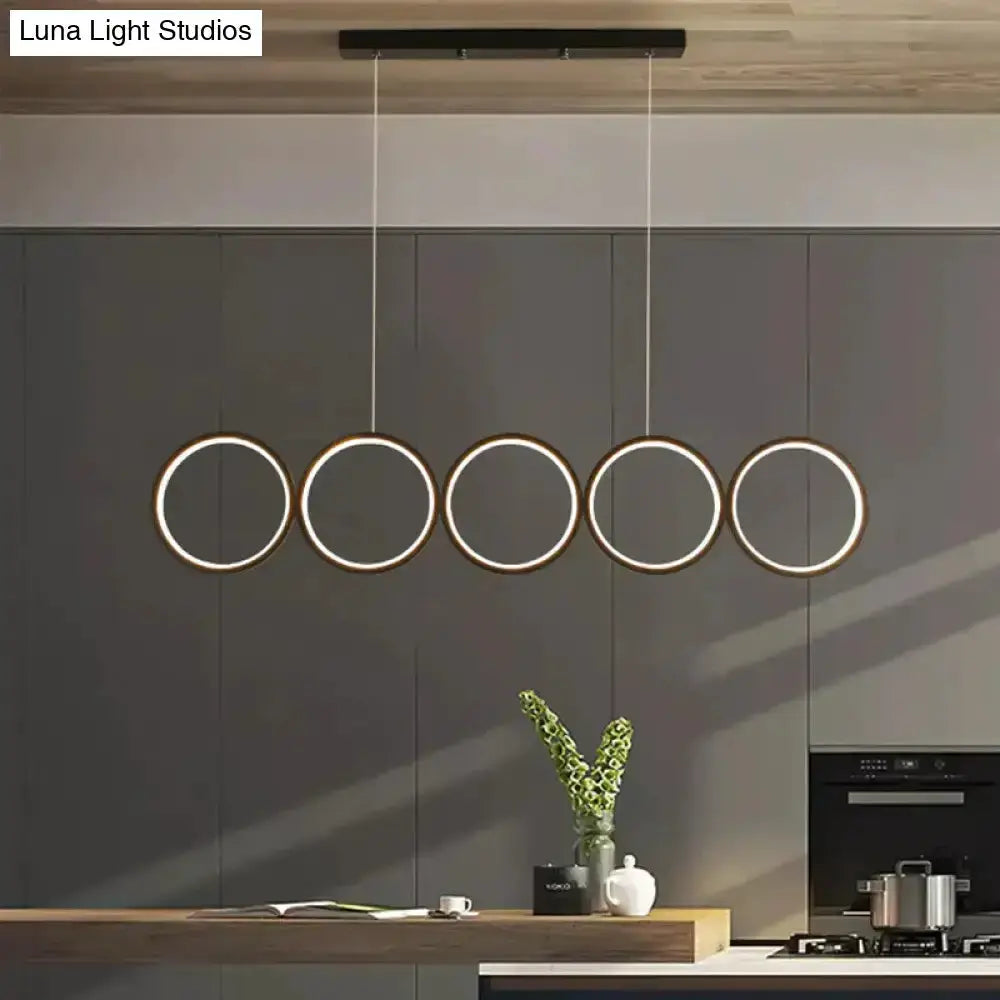 Modern black 5-ring LED pendant light over a kitchen island by Decorbites on Tampa Home & Garden Store