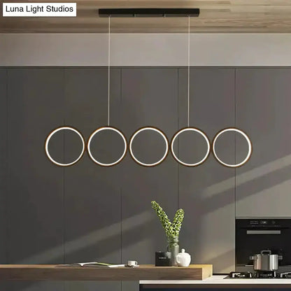 Modern black 5-ring LED pendant light over a kitchen island by Decorbites on Tampa Home & Garden Store