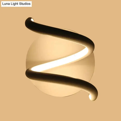 Modern black acrylic spiral sconce with warm LED glow and round back plate Decorbites on Tampa Home & Garden Store