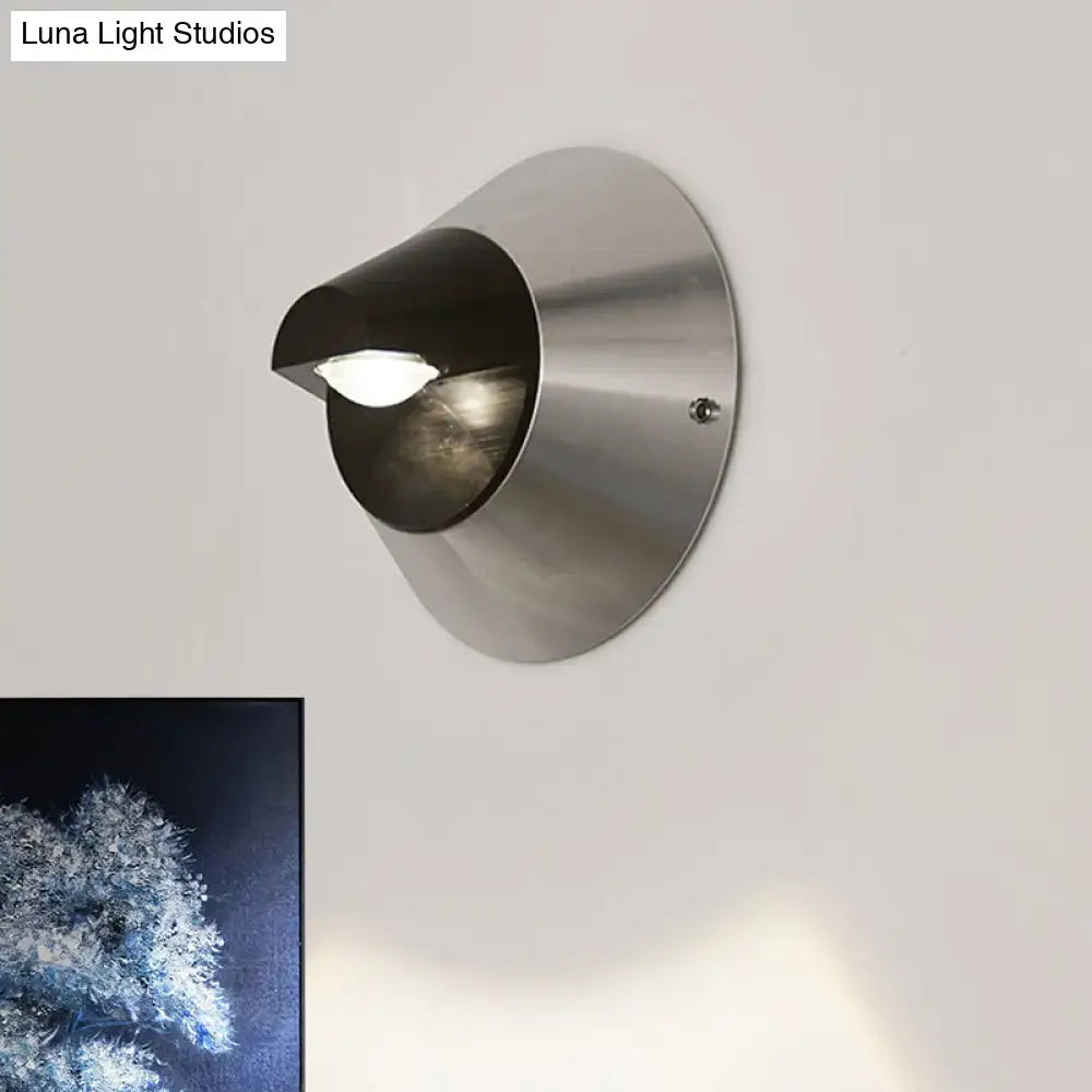 Black steel wall sconce with round brushed metal backplate and curved shade on Tampa Home & Garden Store