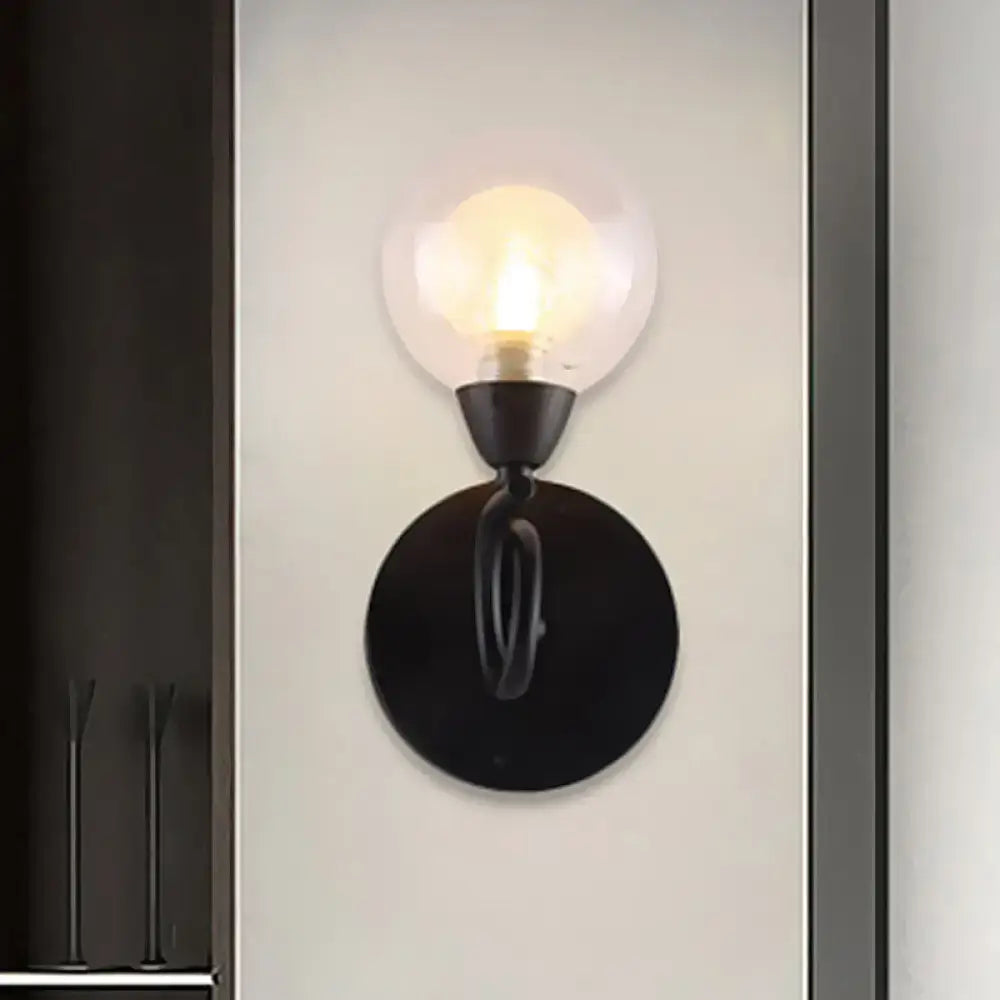 Black wall lamp with a clear glass globe and round black backplate, exposed bulb on Tampa Home & Garden Store
