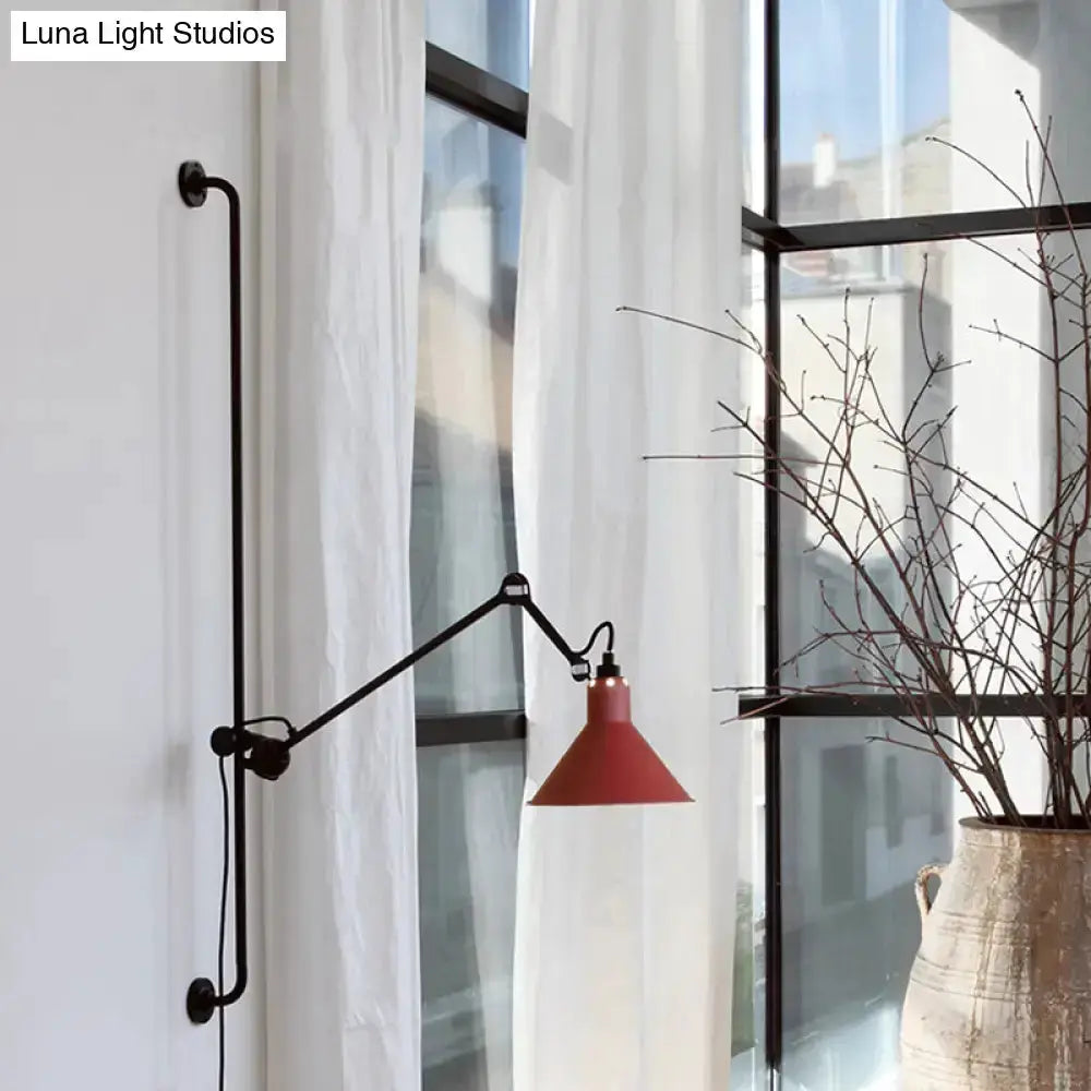 Articulated black metal wall lamp with red cone shade by window in a modern bedroom on Tampa Home & Garden Store