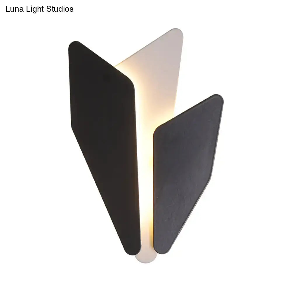 Black geometric metal wall light with overlapping panels, warm glow Decorbites on Tampa Home & Garden Store